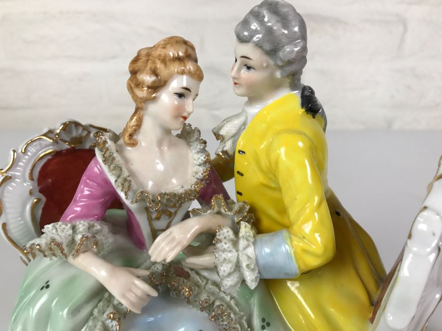 Hand Painted Figurine Of Man And Woman Embracing On Chairs