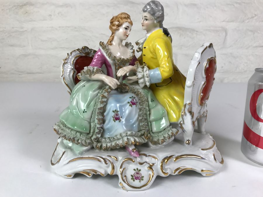 Hand Painted Figurine Of Man And Woman Embracing On Chairs