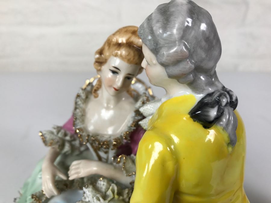 Hand Painted Figurine Of Man And Woman Embracing On Chairs