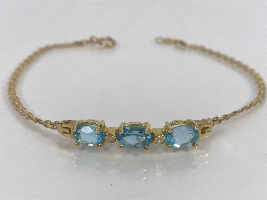 JUST ADDED - 14k Gold Bracelet With (3) Synthetic Blue Topaz Stones Accented With (2) Clear Stones 7 1/2' Long 4.2g [Photo 1]