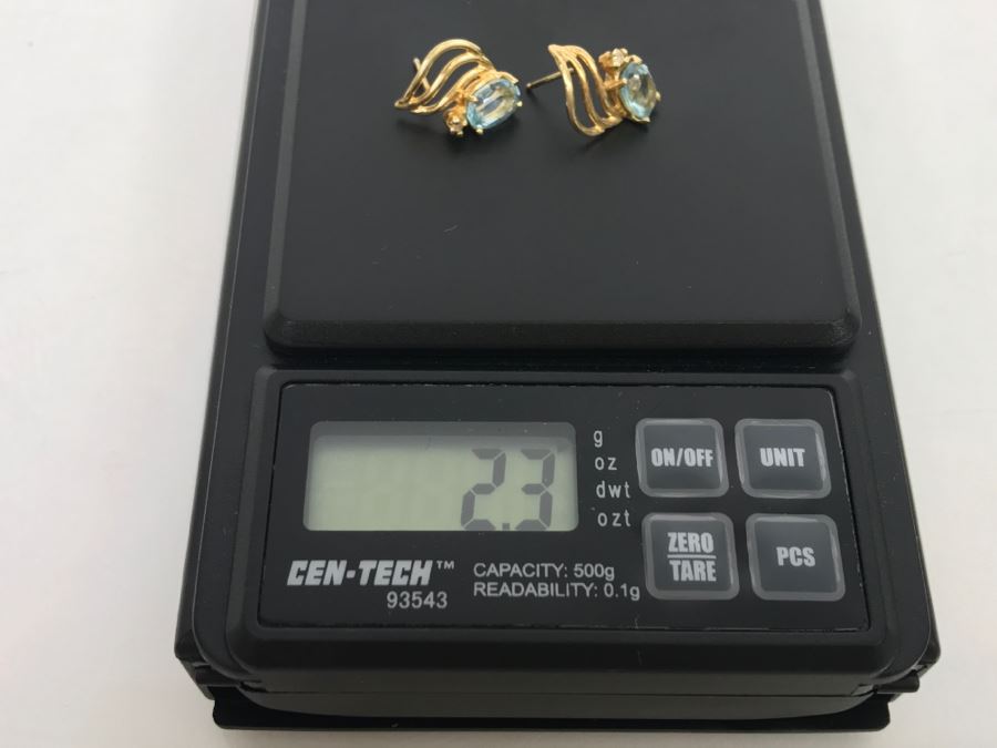 JUST ADDED - 14k Gold Oval Stud Earrings 4 Prong Set With Light Blue Stones Accented With Small 4 Prong Clear Stone With Yellow Gold Fluting 2.3g [Photo 6]