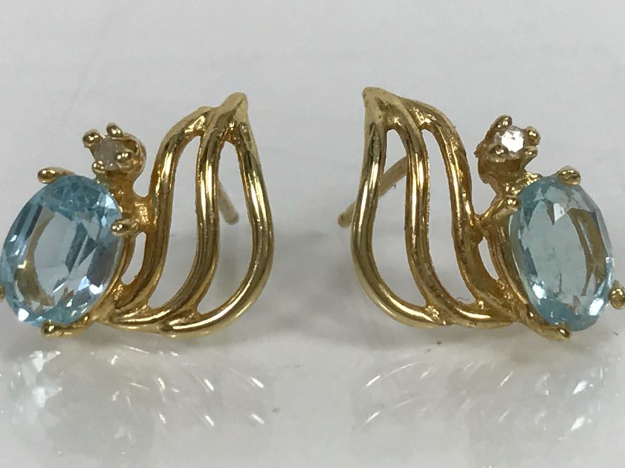 JUST ADDED - 14k Gold Oval Stud Earrings 4 Prong Set With Light Blue Stones Accented With Small 4 Prong Clear Stone With Yellow Gold Fluting 2.3g [Photo 1]