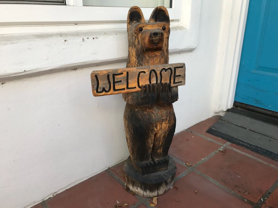 Wooden Carved Bear Statue That Holds Sign Reading 'Welcome' On One Side, 'Go Away' On Other [Photo 1]