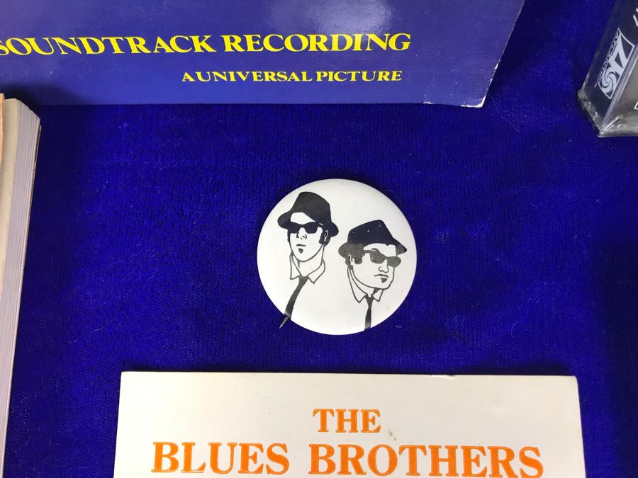 Vintage 1980 The Blues Brothers Movie Memorabilia Lot: Promo Vinyl Record, Sealed Cassette Tape, Button, 1979 Movie Concert Sticker, Blues Brothers Album Sticker, Bluesmobile Die-Cast Metal Replica Car On Damaged Card, And Private Perigee Book [Photo 4]