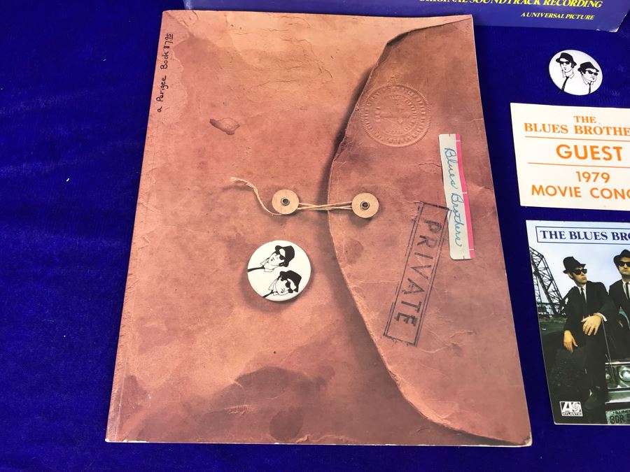 Vintage 1980 The Blues Brothers Movie Memorabilia Lot: Promo Vinyl Record, Sealed Cassette Tape, Button, 1979 Movie Concert Sticker, Blues Brothers Album Sticker, Bluesmobile Die-Cast Metal Replica Car On Damaged Card, And Private Perigee Book [Photo 5]