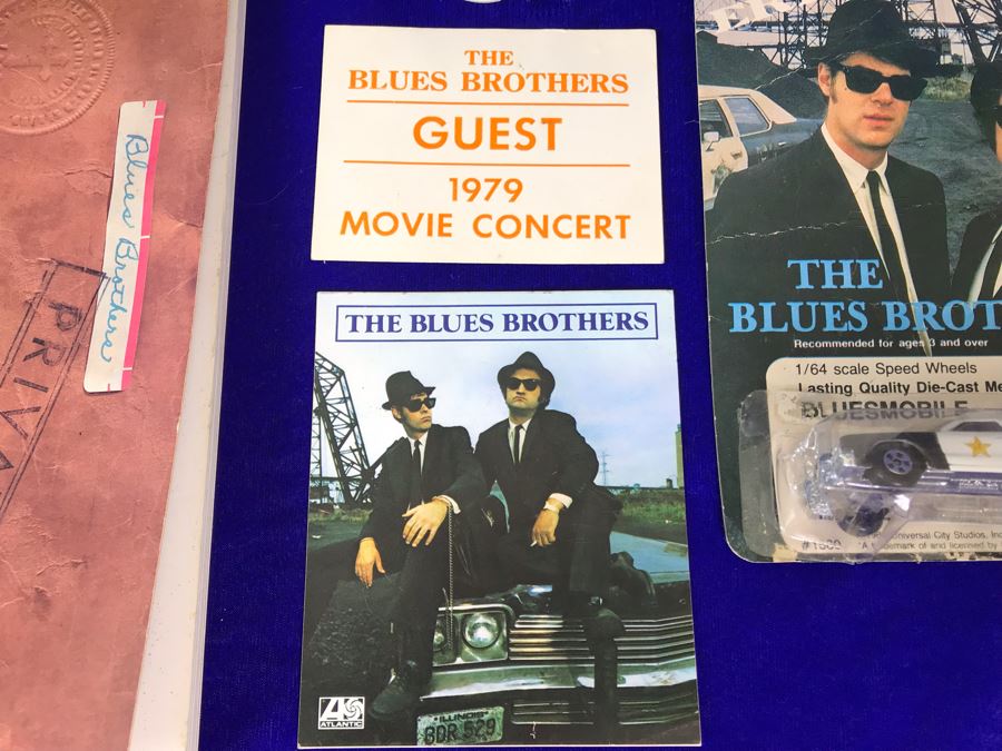 Vintage 1980 The Blues Brothers Movie Memorabilia Lot: Promo Vinyl Record, Sealed Cassette Tape, Button, 1979 Movie Concert Sticker, Blues Brothers Album Sticker, Bluesmobile Die-Cast Metal Replica Car On Damaged Card, And Private Perigee Book [Photo 3]