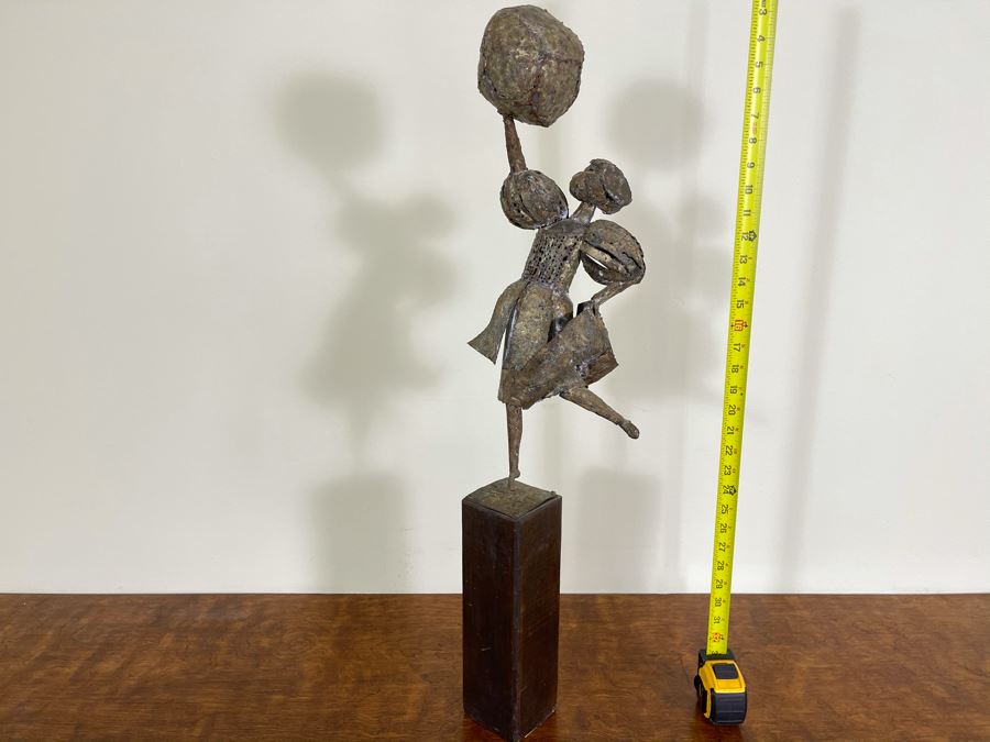 Metal Sculpture Of Woman Holding Up Ball On Wooden Base [Photo 1]