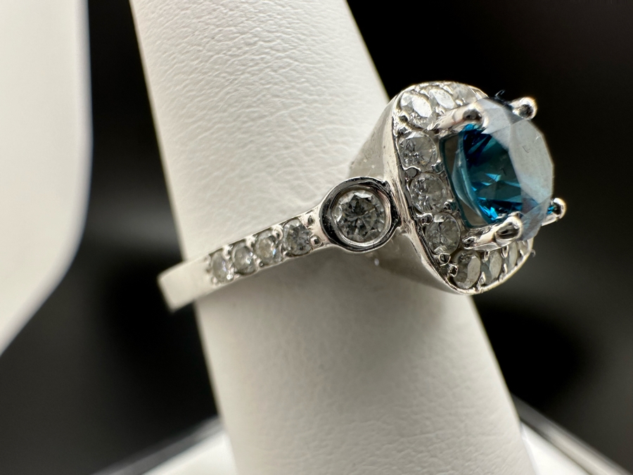 14K Gold Blue Zircon Ring Set With 25 Round Brilliant Diamonds Est. .35cttw Center Stone Blue Zircon 6.4mm X 6.4mm Est. 1cttw Size 6.5 4.8g Estimate Fair Market Value $800 Retail Value $2,400 [Photo 9]