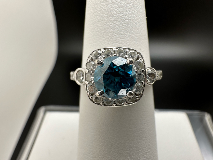 14K Gold Blue Zircon Ring Set With 25 Round Brilliant Diamonds Est. .35cttw Center Stone Blue Zircon 6.4mm X 6.4mm Est. 1cttw Size 6.5 4.8g Estimate Fair Market Value $800 Retail Value $2,400 [Photo 4]