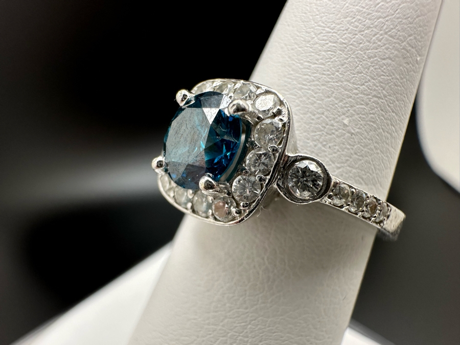 14K Gold Blue Zircon Ring Set With 25 Round Brilliant Diamonds Est. .35cttw Center Stone Blue Zircon 6.4mm X 6.4mm Est. 1cttw Size 6.5 4.8g Estimate Fair Market Value $800 Retail Value $2,400 [Photo 11]