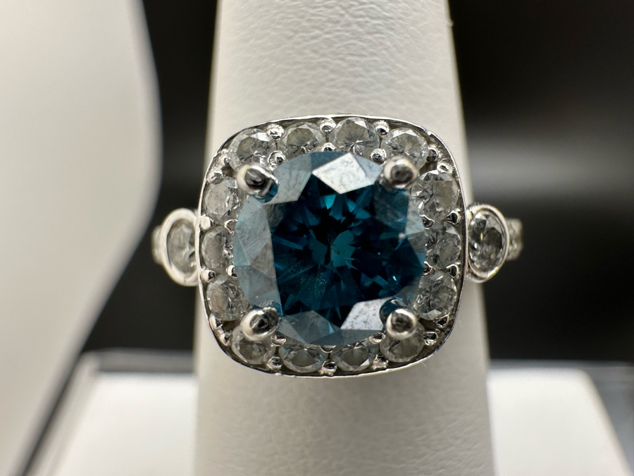 14K Gold Blue Zircon Ring Set With 25 Round Brilliant Diamonds Est. .35cttw Center Stone Blue Zircon 6.4mm X 6.4mm Est. 1cttw Size 6.5 4.8g Estimate Fair Market Value $800 Retail Value $2,400 [Photo 5]