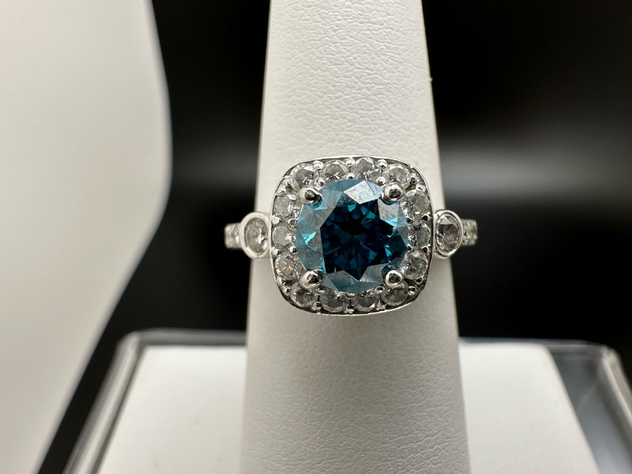14K Gold Blue Zircon Ring Set With 25 Round Brilliant Diamonds Est. .35cttw Center Stone Blue Zircon 6.4mm X 6.4mm Est. 1cttw Size 6.5 4.8g Estimate Fair Market Value $800 Retail Value $2,400 [Photo 6]