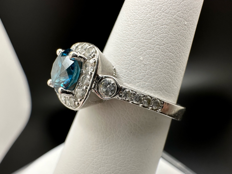 14K Gold Blue Zircon Ring Set With 25 Round Brilliant Diamonds Est. .35cttw Center Stone Blue Zircon 6.4mm X 6.4mm Est. 1cttw Size 6.5 4.8g Estimate Fair Market Value $800 Retail Value $2,400 [Photo 13]