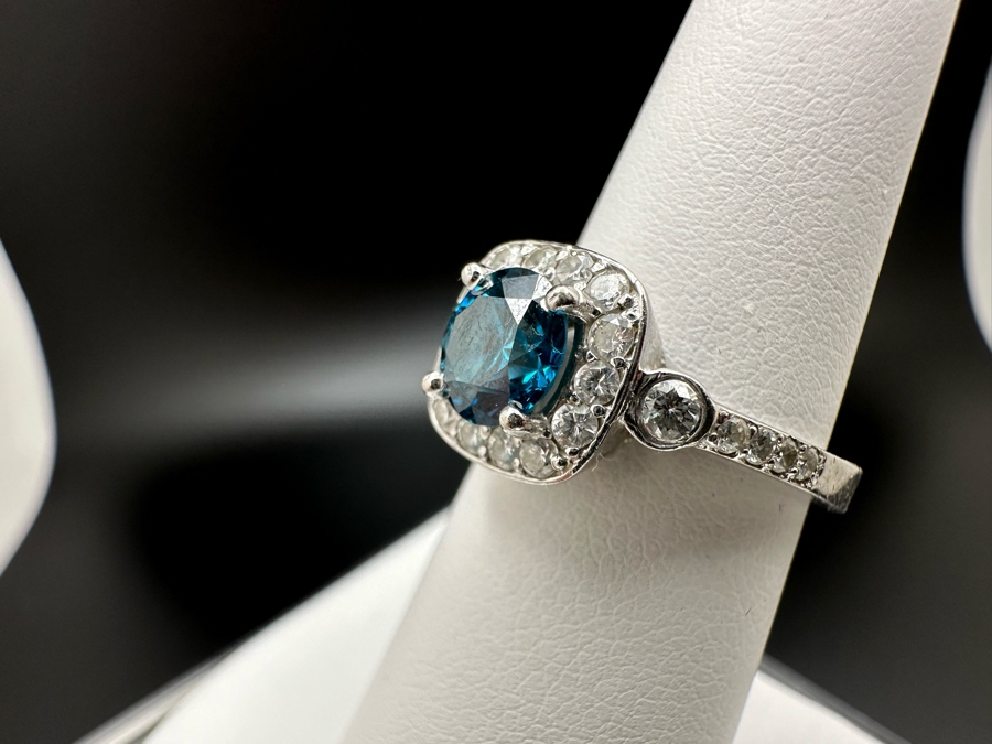 14K Gold Blue Zircon Ring Set With 25 Round Brilliant Diamonds Est. .35cttw Center Stone Blue Zircon 6.4mm X 6.4mm Est. 1cttw Size 6.5 4.8g Estimate Fair Market Value $800 Retail Value $2,400 [Photo 10]