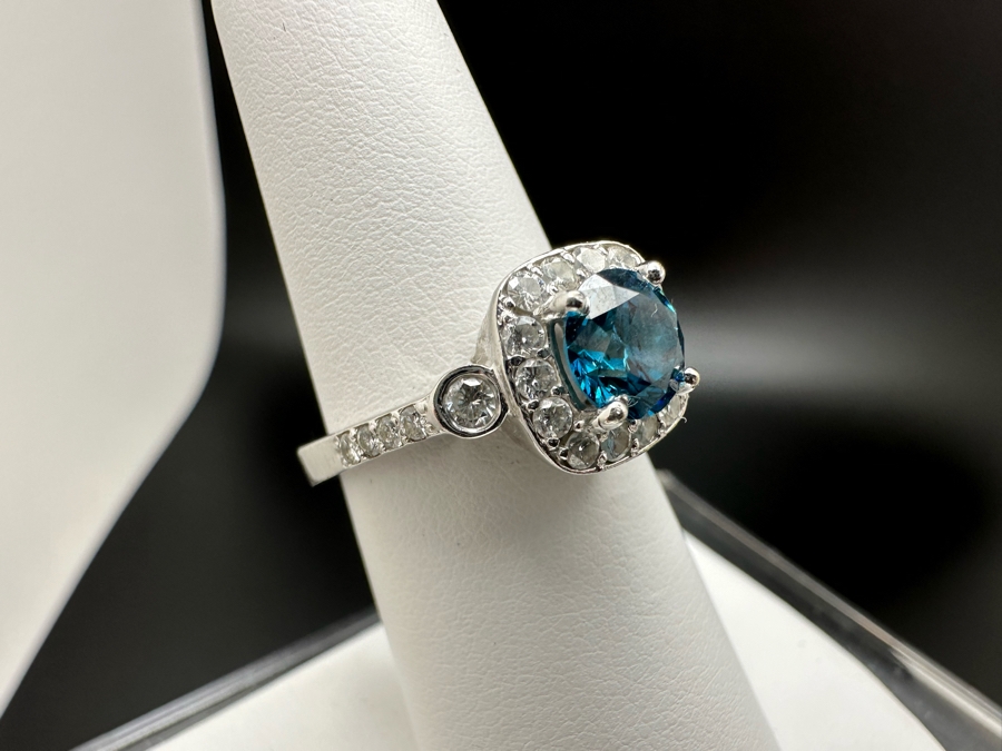 14K Gold Blue Zircon Ring Set With 25 Round Brilliant Diamonds Est. .35cttw Center Stone Blue Zircon 6.4mm X 6.4mm Est. 1cttw Size 6.5 4.8g Estimate Fair Market Value $800 Retail Value $2,400 [Photo 7]