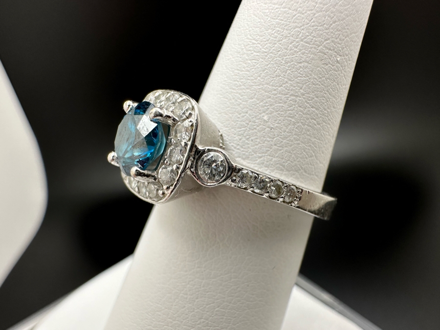 14K Gold Blue Zircon Ring Set With 25 Round Brilliant Diamonds Est. .35cttw Center Stone Blue Zircon 6.4mm X 6.4mm Est. 1cttw Size 6.5 4.8g Estimate Fair Market Value $800 Retail Value $2,400 [Photo 12]