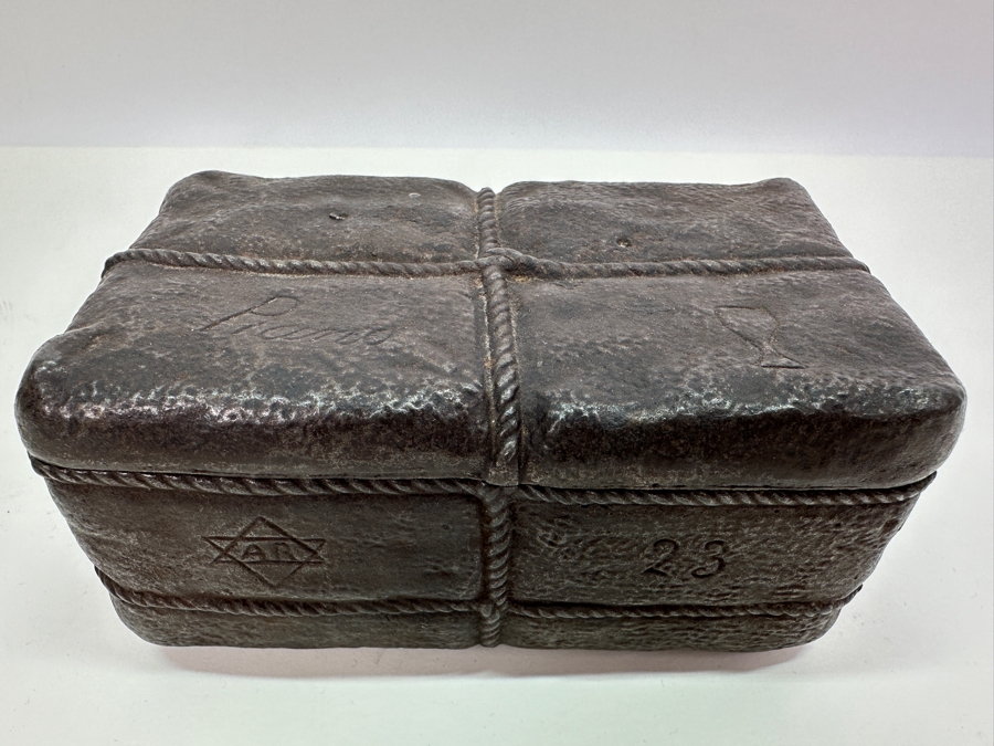 Antique Cast Iron Tobacco Jar In Shape Of A Package Wrapped With Rope Bearing An AR Star, The Number 23, The Word Piano And A Glass With Makers Mark Underneath Box [Photo 7]