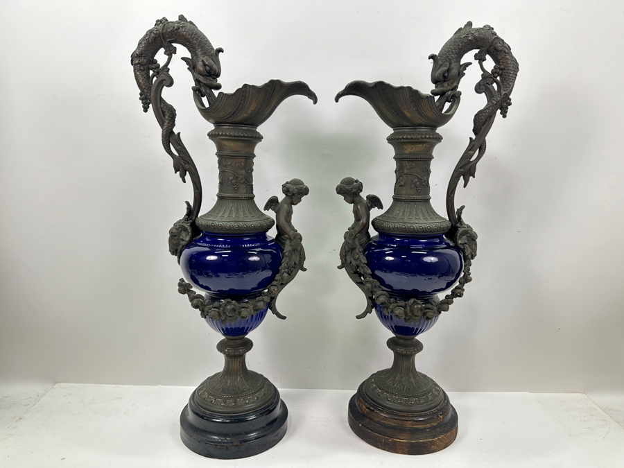 Pair Of French Decorative Ewers With Dolphin Handles And Cherub Figure - Note That A Piece Of The Metal Is Missing On One Ewer On Wooden Base 25.5'H [Photo 2]