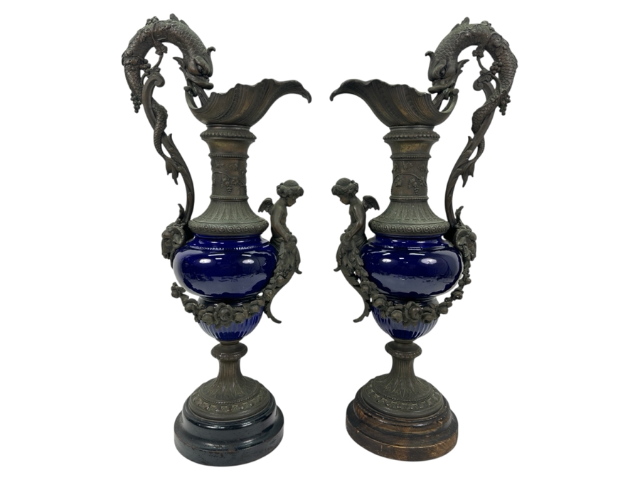 Pair Of French Decorative Ewers With Dolphin Handles And Cherub Figure - Note That A Piece Of The Metal Is Missing On One Ewer On Wooden Base 25.5'H [Photo 1]