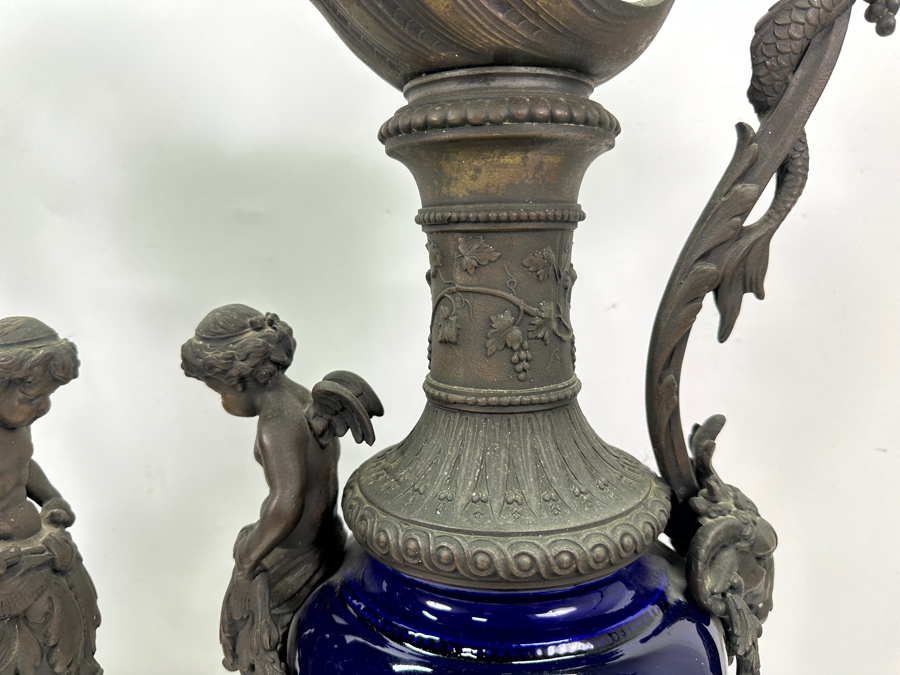 Pair Of French Decorative Ewers With Dolphin Handles And Cherub Figure - Note That A Piece Of The Metal Is Missing On One Ewer On Wooden Base 25.5'H [Photo 9]