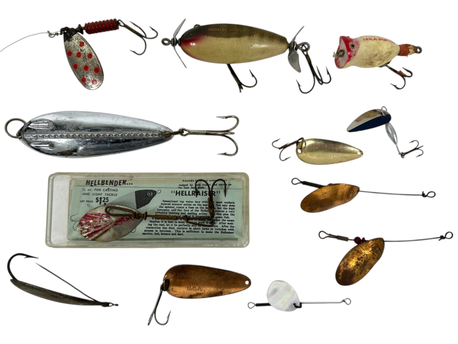 Collection Of Vintage Fishing Lures Including A Hellbender 'Hellraiser' Topwater Lure In Original Box, Johnson Silver Minnow Spoon, And Various Other Spinners And Spoons From The Mid-20th Century. 
