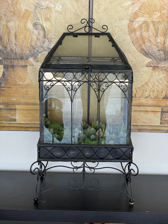 Victorian Style Wrought Iron Wardian Case Terrarium Featuring Gothic Arched Glass Panels And An Ornate Scrolled Stand With Faux Succulent Garden Display 18'W X 12'D X 30'H